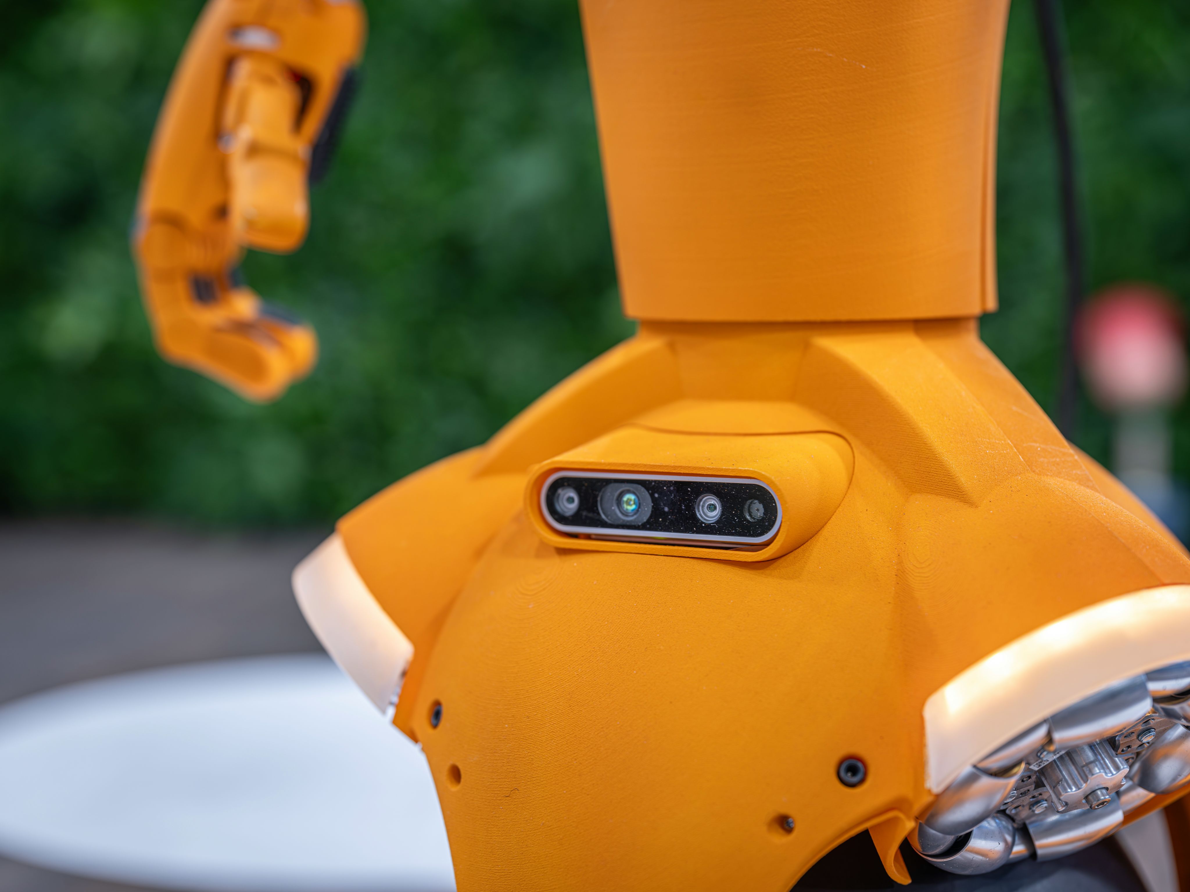 Close-up of an orange robot with a sensor array.
